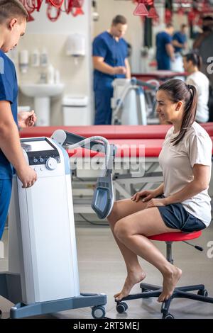 Médecin utilisant une machine pour traiter les articulations du genou d'un patient. Banque D'Images