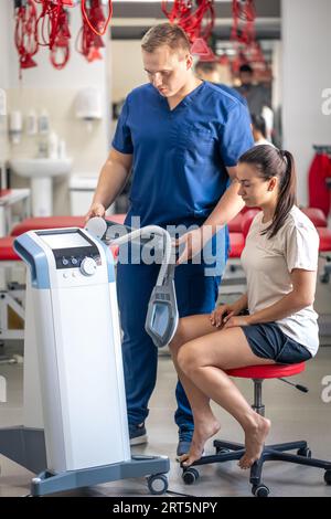 Médecin utilisant une machine pour traiter les articulations du genou d'un patient. Banque D'Images