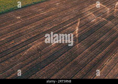 Arroseurs d'irrigation à roues agricoles en champ cultivé, prise de vue aérienne du drone pov de matériel agricole, vue à grand angle Banque D'Images