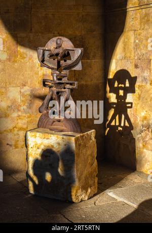 Sculpture figurative abstraite en fer forgé illuminée par la lumière du soleil du soir et sur son piédestal l'ombre de deux personnes. L'ombre du sculptu Banque D'Images