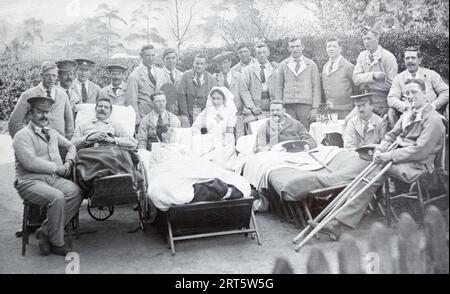 Infirmière du détachement de secours volontaires de l'Ambulance Saint-Jean entourée de soldats britanniques en convalescence pendant la première Guerre mondiale. Banque D'Images