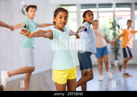 Joyeux garçon et fille préadolescents à la peau foncée dansant lentement foxtrot en paire Banque D'Images