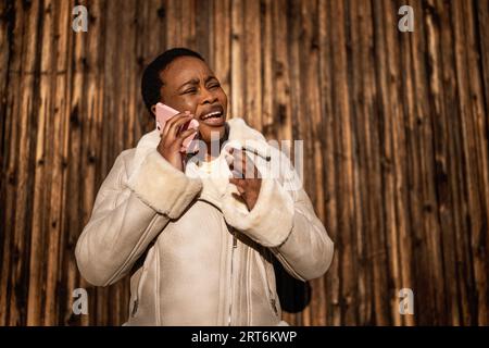 Portrait extérieur de femme afro-américaine. Elle parle au téléphone. Banque D'Images