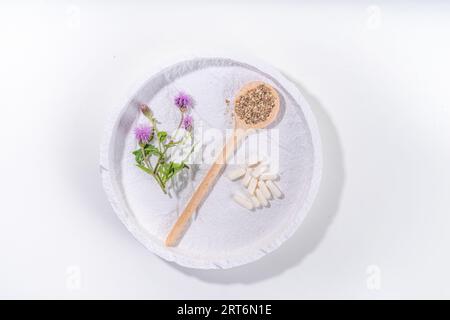 Fournitures de chardon de lait, poudre et huile. Silybum marianum, superaliment biologique naturel de fleurs sauvages - graines entières et de grains, pilules, huile avec frais Banque D'Images