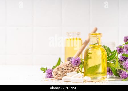 Fournitures de chardon de lait, poudre et huile. Silybum marianum, superaliment biologique naturel de fleurs sauvages - graines entières et de grains, pilules, huile avec frais Banque D'Images