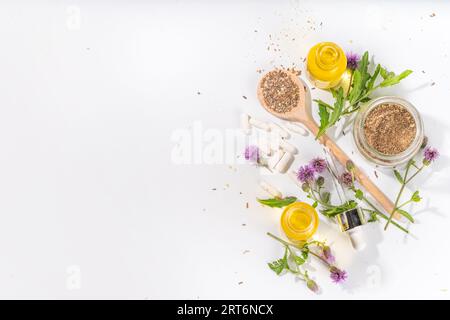 Fournitures de chardon de lait, poudre et huile. Silybum marianum, superaliment biologique naturel de fleurs sauvages - graines entières et de grains, pilules, huile avec frais Banque D'Images