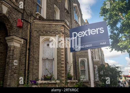 LONDRES- 15 AOÛT 2023 : Agent immobilier Dexters pour la vente signe sur la rue des maisons dans l'ouest de Londres Banque D'Images