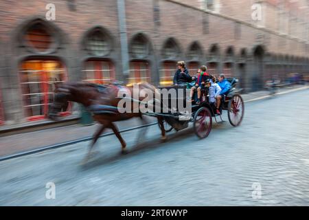 Bruges, Belgique, août 20 2014, Motion Photographie floue de touristes lors d'une visite guidée dans une calèche tirée par des chevaux Banque D'Images