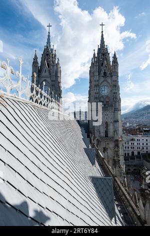 Basilique du vœu National une église catholique romaine contre les bâtiments urbains sous le ciel bleu situé dans le centre historique de Quito, Équateur Banque D'Images