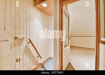 Porte blanche de la chambre située à proximité de photos encadrées et lampe élégante sur le dessus de l'escalier à la maison Banque D'Images