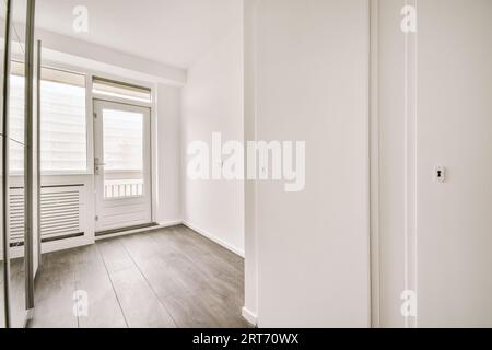 Fenêtre et porte près du radiateur sur le mur blanc dans la pièce lumineuse vide à la maison Banque D'Images