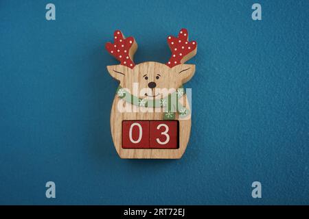 Cerf en bois festif avec Viva Magenta cubes 03 sur fond bleu vue de dessus rapprochée. Concept de Noël de date Banque D'Images