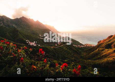 Beau paysage tourné de la côte avec des collines et l'océan sur fond dans les îles Canaries - Tenerife. Coucher de soleil sur les sommets des montagnes et le village avec Banque D'Images