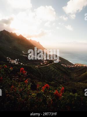 Beau paysage tourné de la côte avec des collines et l'océan sur fond dans les îles Canaries - Tenerife. Coucher de soleil sur les sommets des montagnes et le village avec Banque D'Images