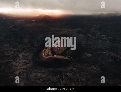 Image de paysage - vue aérienne du volcan à Lanzarote au coucher du soleil. Photo Moody et sombre - panorama de l'île de lave noire. Banque D'Images