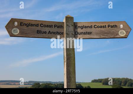 Un panneau en bois indiquant la direction. England Coast Path Blue Anchor et England Coast Path Dunster. Banque D'Images