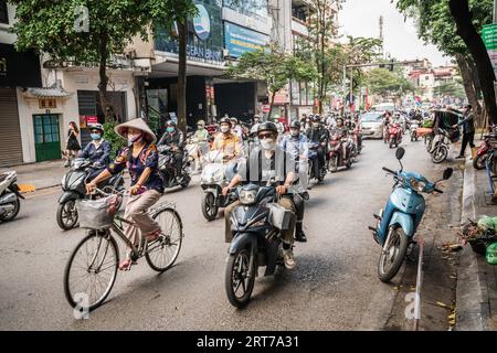 Hanoi, Vietnam, 13 novembre 2022 : circulation de scooters et de vélos dans une rue latérale animée à Hanoi, Vietnam Banque D'Images