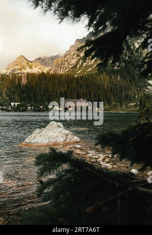 Photo de beau lac avec de l'eau cristalline situé dans les Hautes Tatras - Slovaquie. Plan vertical de Popradske pleso avec d'énormes montagnes et la forêt o Banque D'Images