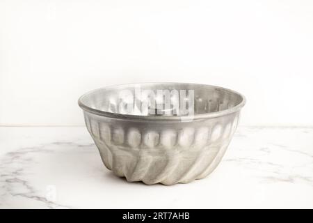 Un moule à pâtisserie sur un comptoir de cuisine en marbre blanc et gris avec espace de copie Banque D'Images