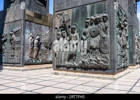 Un relief en bronze du Christ portant la croix orne la base d'un pilier de la Chronique de Géorgie (géorgien საქართველოს მატიანე, Sakartvelos Matiane) sur le mont Kenisi au-dessus de la mer de Tbilissi, un réservoir, dans le district de Nadzaladevi de Tbilissi, en Géorgie. Le Christ, avec un halo, porte la croix sur son épaule. Des guerriers avec des boucliers ronds se pressent derrière lui, des hommes barbus se tiennent à gauche. Une inscription géorgienne court au-dessus de la scène. Le panneau sur le pilier voisin à gauche montre deux figures, l'une avec un halo, à côté d'un arbre. Le sculpteur Zurab Tsereteli a commencé le complexe en 1985. Il est composé de 1 Banque D'Images