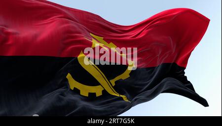 Le drapeau national de l'Angola agitant dans le vent par temps clair. Deux bandes horizontales, rouge et noire, avec un emblème jaune au centre. illustration 3d. Banque D'Images