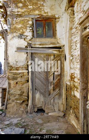Porte rustique en bois dans une vieille maison de village turque construite en pierre. Banque D'Images