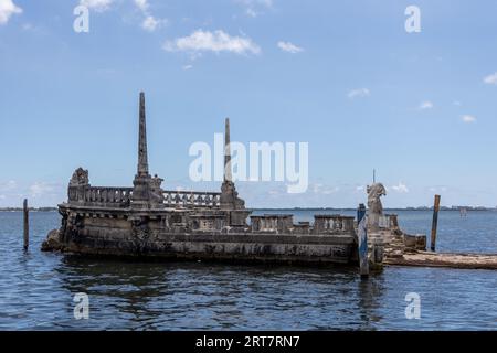 Miami, Floride - 25 août 2023 : Péniche brise-lames en pierre et magnifique Mansion Vizcaya sur la baie de Biscayne sous le ciel bleu. Banque D'Images