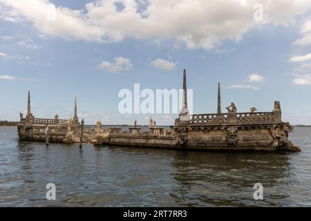 Miami, Floride - 25 août 2023 : Péniche brise-lames en pierre et magnifique Mansion Vizcaya sur la baie de Biscayne sous le ciel bleu. Banque D'Images