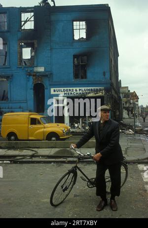 Brixton Riots 1980s Royaume-Uni. Le lendemain de l'émeute, un homme du coin sur son vélo de poussée a regardé les dommages causés à ce quartier. Bâtiments Burnout. Brixton South London Royaume-Uni avril 1981 Angleterre HOMER SYKES. Banque D'Images