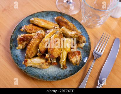 Il y a une collation copieuse sur l'assiette - une grande portion d'ailes de poulet frites Banque D'Images