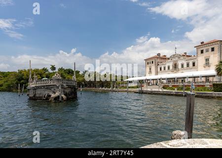 Miami, Floride - 25 août 2023 : Péniche brise-lames en pierre et magnifique Mansion Vizcaya sur la baie de Biscayne sous le ciel bleu. Banque D'Images