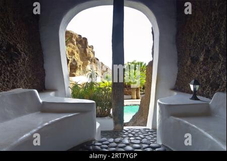 Nazaret, Lanzarote, Îles Canaries, Espagne - 23 mars 2023 : vue depuis une salle de bar sur la piscine de la maison Lagomar, construite dans la roche par Cesar Manrique. Banque D'Images