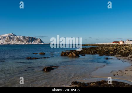 La célèbre plage de sable tropicale près de Ramberg sur l' Îles Lofoten en Norvège par temps clair d'hiver avec neige montagnes et ciel bleu Banque D'Images
