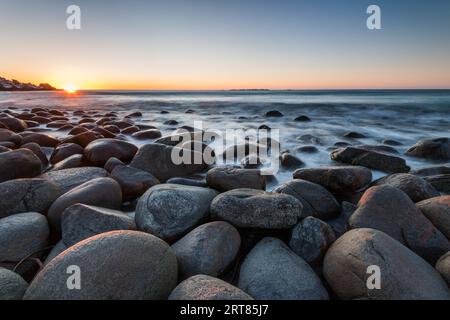 La célèbre plage près de Uttakleiv avec des rochers de forme ronde sur les îles Lofoten en Norvège sur la journée claire d'hiver avec des montagnes enneigées et Banque D'Images