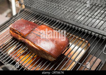 Prêt à manger du jambon grillé de style Prague sur une grille de fumeur barbecue Banque D'Images