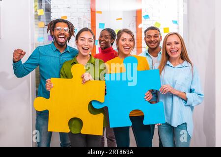 Travail d'équipe de partenaires qui travaillent avec puzzle comme concept d'intégration et de démarrage Banque D'Images