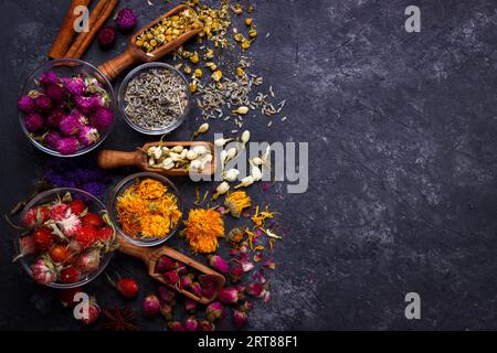 Assortiment de thé de fleurs sèches sur noir ardoise with copy space Banque D'Images