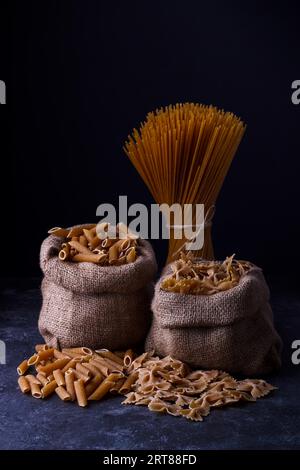 Spaghetti de pâtes séchées de grain entier pour une alimentation saine, faible, fond sombre Banque D'Images