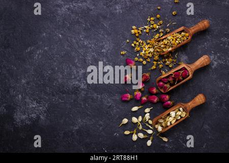 Assortiment de thé de fleurs sèches sur noir ardoise with copy space Banque D'Images