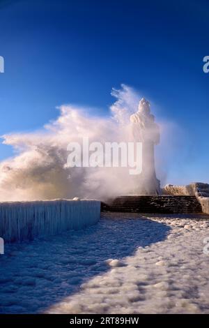 Phare gelé et jetée le jour d'hiver orageux Banque D'Images