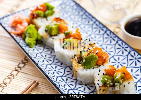 Rouleaux de sushi Uramaki avec saumon, crabe, avocat et concombre Banque D'Images