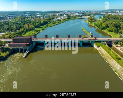 Cracovie, Pologne. Barrage de Dabie sur la rivière Vistule avec pont et petite centrale hydroélectrique sur la gauche et écluse sur la droite. Vieille ville avec wawe Banque D'Images