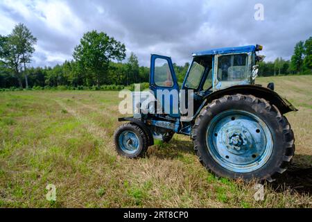Vieux tracteurs agricoles russes bleus dans le champ. Machines agricoles dans la ferme. Équipement agricole spécial. Machine agricole durable Banque D'Images
