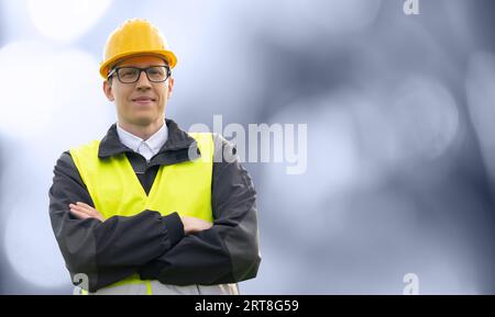 Portrait d'un ingénieur souriant dans des lunettes, casque et costume bleu regardant la caméra. Isolé... Banque D'Images