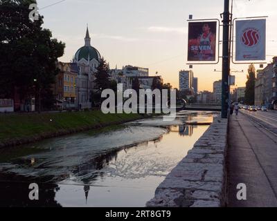 Bâtiment avec dôme le long de la rivière Miljacka un soir d'été dans la ville de Sarajevo, Bosnie-Herzégovine, 11 septembre 2023 Banque D'Images