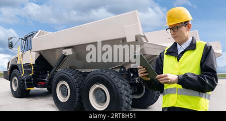 Réaliser des travaux d'ingénierie avec des tablettes à côté du camion minier. Banque D'Images