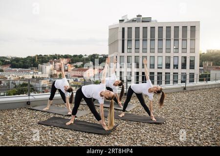 Yoginis debout dans asana avec les mains levées à l'extérieur Banque D'Images