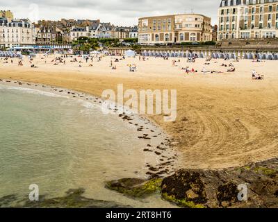 Vue imprenable sur la plage de Dinard avec des villas historiques et des cabanes traditionnelles rayées bleu-blanc, côte atlantique de Bretagne, France Banque D'Images