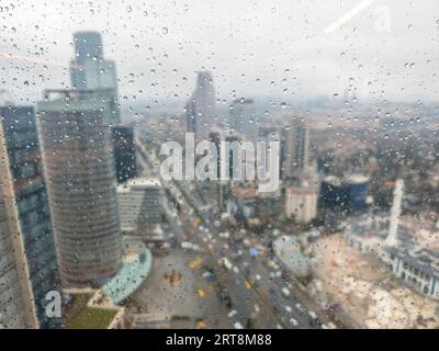 istanbul, Turquie -17 mars 2023 : quartier financier de Levent avec des gratte-ciel et de la circulation par jour de pluie comme vu derrière une fenêtre humide avec des gouttes de pluie Banque D'Images