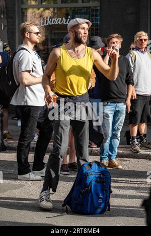 Homme avec débardeur jaune dansant sur la musique à Kallio Block Party 2023 à Helsinki, Finlande Banque D'Images